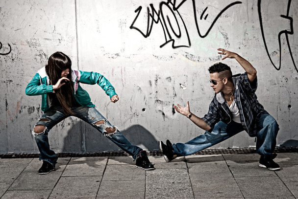 Young urban couple dancers hip hop dancing fight acting urban scene - Foto, afbeelding