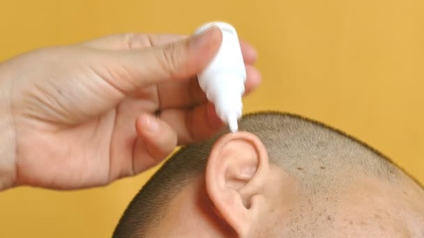 Gieten medische druppels in oren voor een otitis genezing. - Video