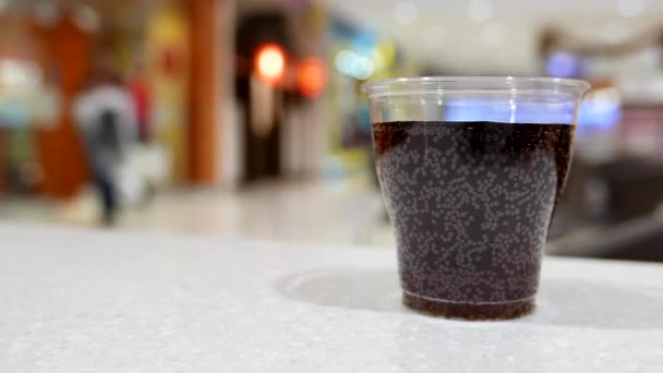 A cup of coca cola on table inside shopping mall - Footage, Video