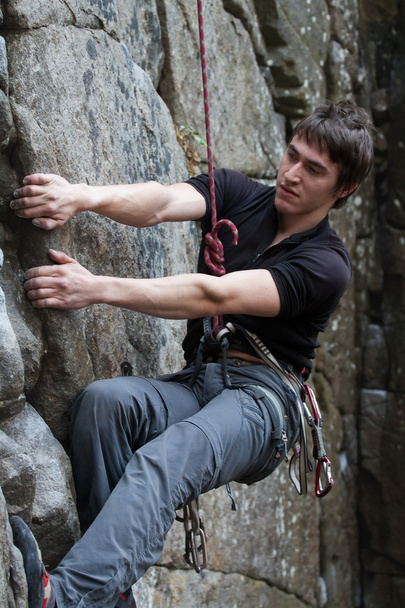 jonge man klimt op een rots - Foto, afbeelding