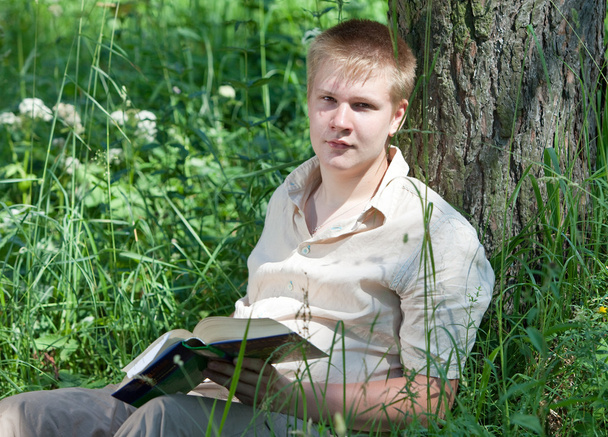 The young man with the book in park - Fotoğraf, Görsel