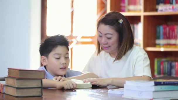Ανάγνωση με δάσκαλο - ένα δημοτικό σχολείο αγόρι διαβάζει δυνατά το δάσκαλό της - Πλάνα, βίντεο