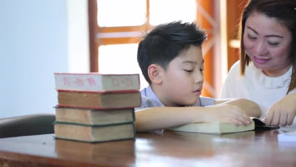 Ανάγνωση με δάσκαλο - ένα δημοτικό σχολείο αγόρι διαβάζει δυνατά το δάσκαλό της - Πλάνα, βίντεο