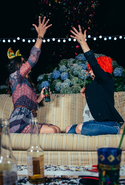 Gelukkig vrouwen gooien confetti aan de lucht in partij - Foto, afbeelding