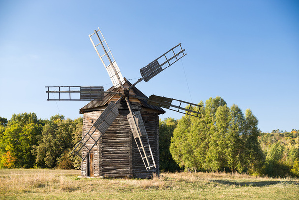 Větrný mlýn, stojící v poli proti modré obloze - Fotografie, Obrázek