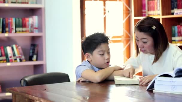 Lendo com o professor - um menino da escola primária lê em voz alta para seu professor
 - Filmagem, Vídeo