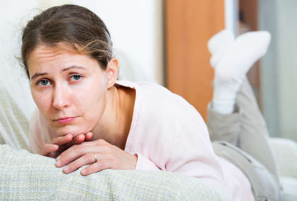 upset woman sitting in domestic interior  - Photo, image