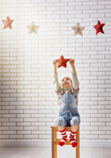 child hangs the stars - Фото, изображение