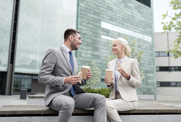 smiling businessmen with paper cups outdoors - Foto, imagen