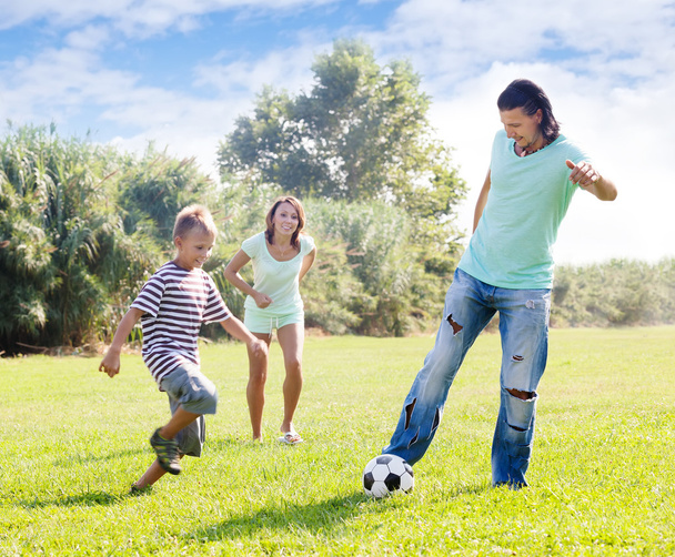 Vanhemmat lapsen kanssa pelaavat jalkapalloa
 - Valokuva, kuva