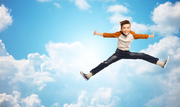 happy smiling boy jumping in air - Фото, изображение