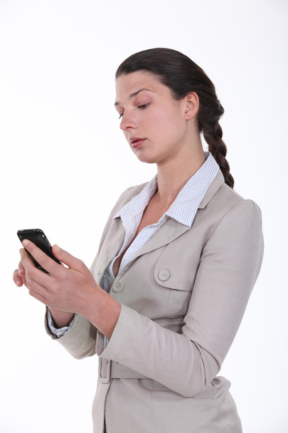 Businesswoman looking at her phone - Zdjęcie, obraz