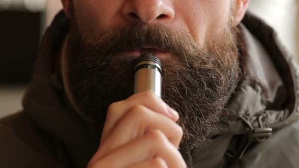 Γενειοφόρος άνδρας κάπνισμα ηλεκτρονικό τσιγάρο - Πλάνα, βίντεο
