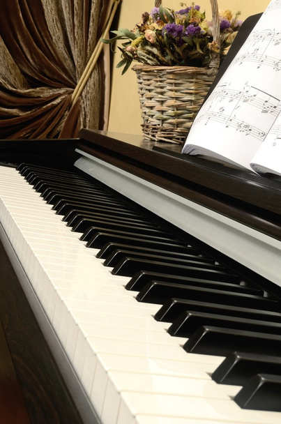 Toetsen home muziekinstrument buffetpiano bekendgemaakt wordt, notities en mand met bloemen - Foto, afbeelding