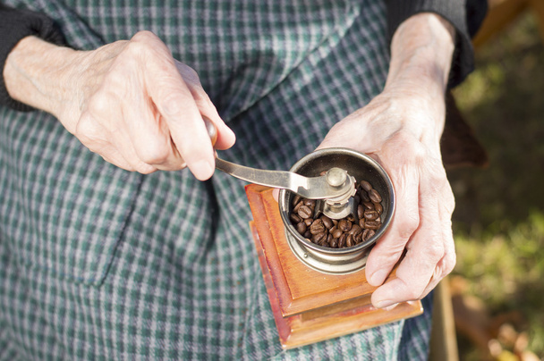 Mani vecchie macinare il caffè su un macinino da caffè vintage
 - Foto, immagini