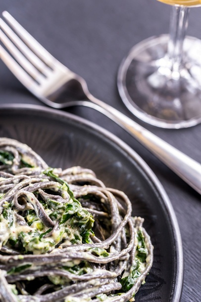 Black pasta with spinach, mascarpone and Parmesan - Photo, Image
