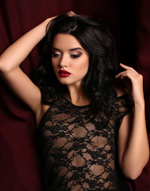 woman with dark hair and evening makeup, wears luxurious black lace dress   - Fotó, kép