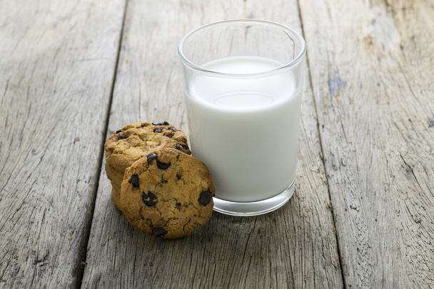 galletas y un vaso con leche sobre mesa de madera
 - Foto, Imagen