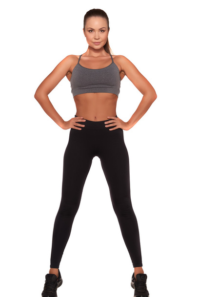 Fitness woman in sport style standing against isolated white background - Zdjęcie, obraz