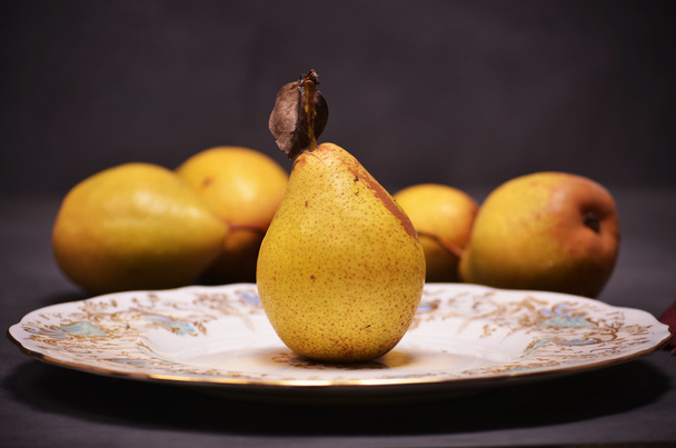 pears in a wooden basket lying on a wooden Background - Foto, afbeelding