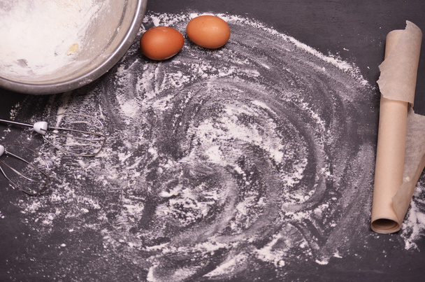 various ingredients for the dough and utensils are laid out on a black background - Photo, Image