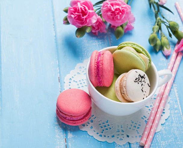 Macarons  and pink flowers on the table close-up - Foto, immagini