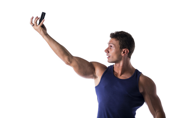Handsome muscular young man taking selfie with cell phone - Photo, image