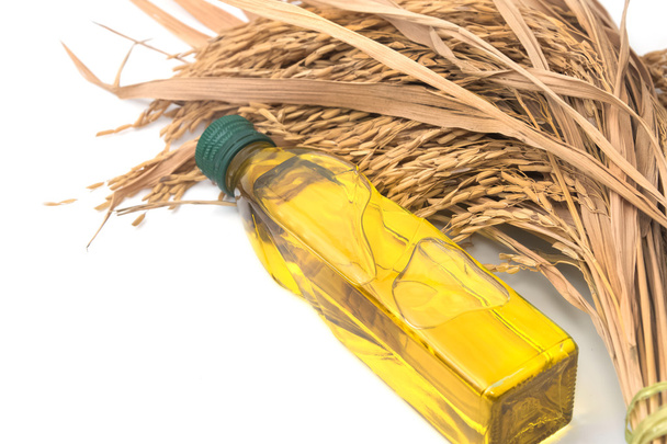Rice bran oil in bottle glass with rice paddy on white - Photo, Image