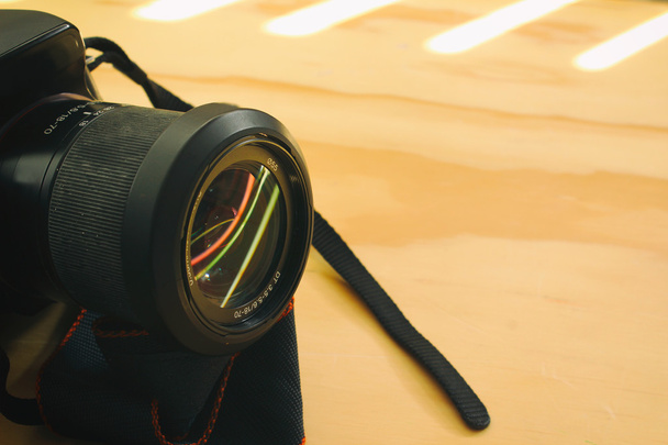 Reflex camera on wood table - Фото, изображение