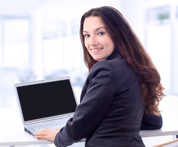 przemyślany biznes kobieta do laptopa w biurze z uśmiechem. - Zdjęcie, obraz