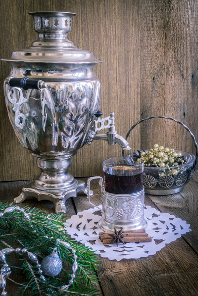 Té en vaso con posavasos y samovar ruso sobre fondo de madera. Casa decoración de Navidad
 - Foto, imagen