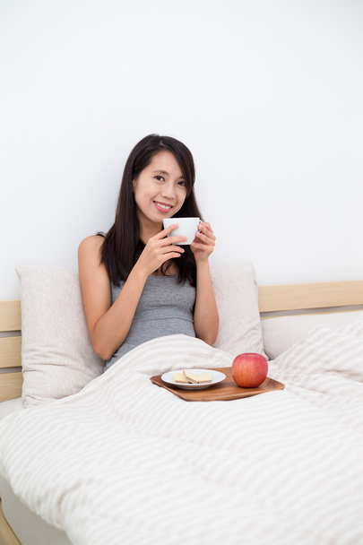 mulher tomando o café da manhã na cama
 - Foto, Imagem