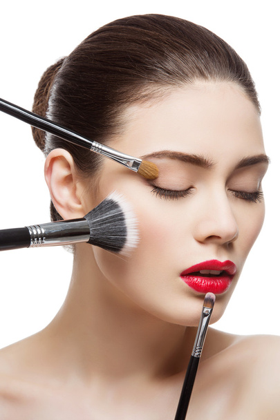Beautiful girl with makeup brushes - 写真・画像