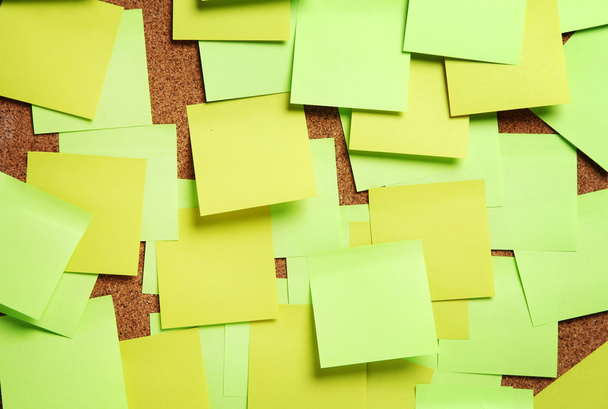 Image of blank green and yellow sticky notes on cork bulletin bo - 写真・画像