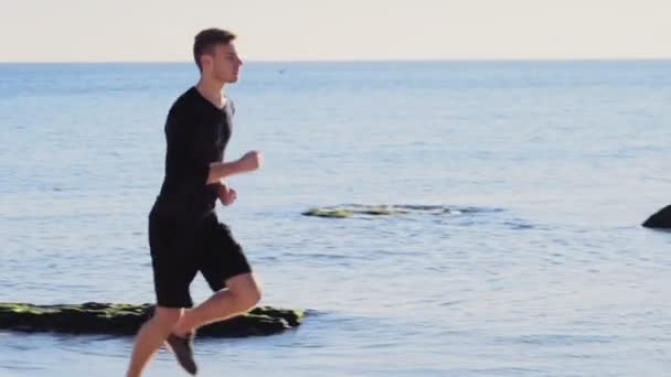 plaj yavaş hareket üzerinde koşan genç adam - Video, Çekim