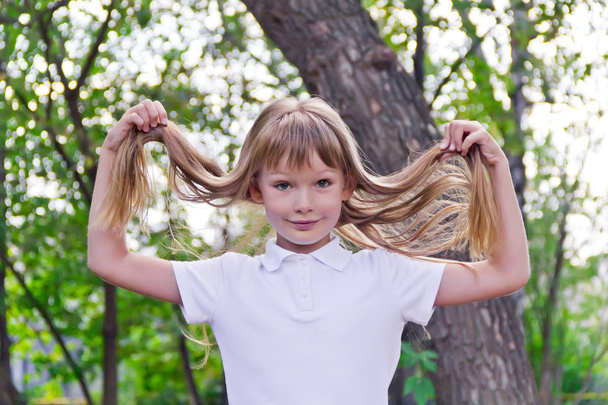 Cute girl playing with long hair - Photo, Image