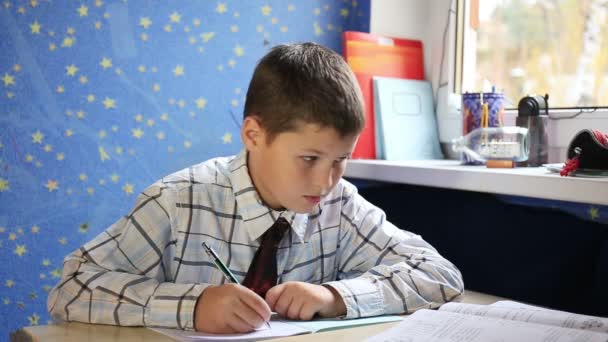 Teenage boy sitting and preparing homework - Кадры, видео
