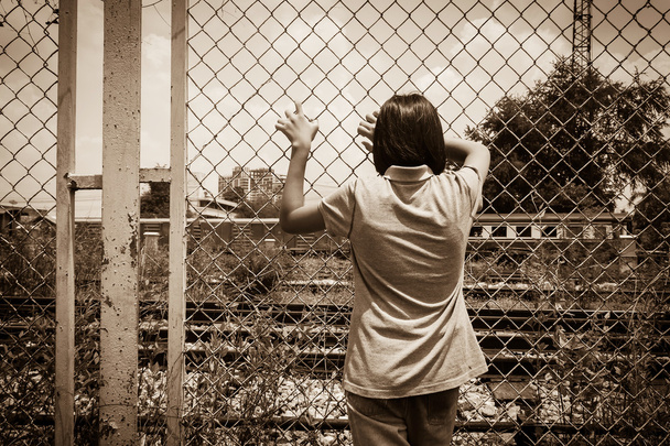 azjatycki mały dziewczyna smutny ręka trzymać więzienia w kolej żelazna, stacja kolejowa - Zdjęcie, obraz