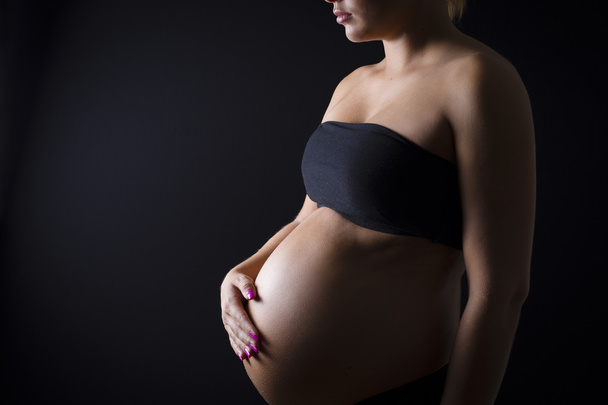 Mujer embarazada con la mano en el vientre desnudo
 - Foto, Imagen