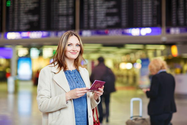 женщина в международном аэропорту ждет рейса в терминале
 - Фото, изображение