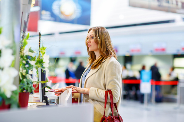 kobieta w międzynarodowym porcie lotniczym, czekając na lot w terminal - Zdjęcie, obraz