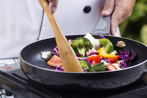 Шеф-повар помешивает жареный овощ
  - Фото, изображение