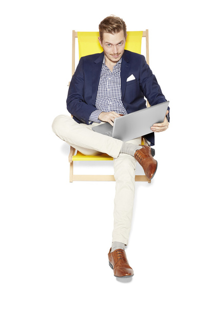 Smugness Man with a laptop sitting on a sunbed - Фото, зображення