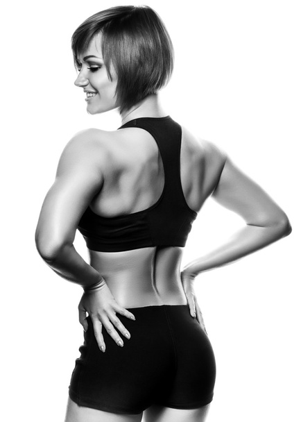 Back view of fit female athlete against of white background - Foto, Bild