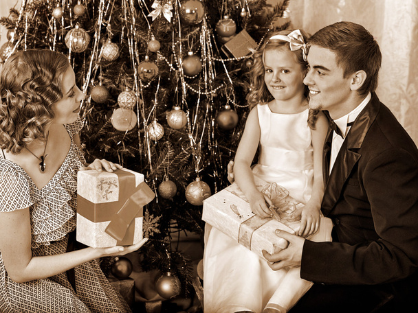 Família de vestir árvore de Natal
 - Foto, Imagem