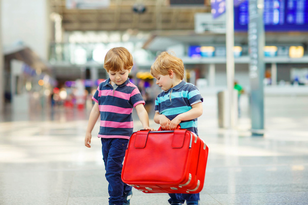Dois meninos irmãos cansados no aeroporto
 - Foto, Imagem