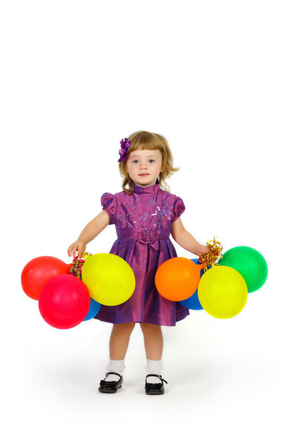 smiling young girl with balloons in their hands in a purple dres - Foto, afbeelding