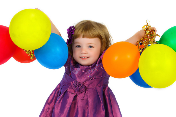 smiling young girl with balloons in their hands in a purple dres - Fotografie, Obrázek