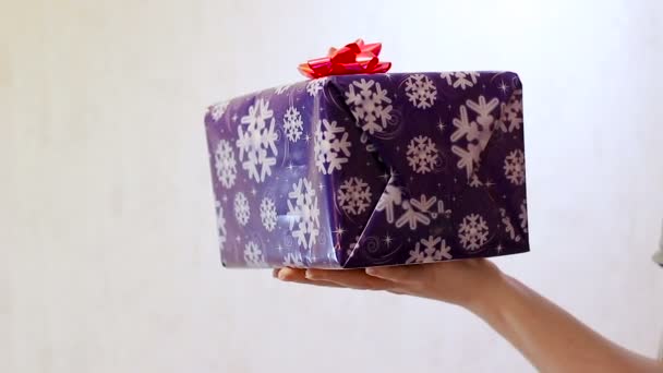 Een meisje houdt een doos met een geschenk Lila - Video