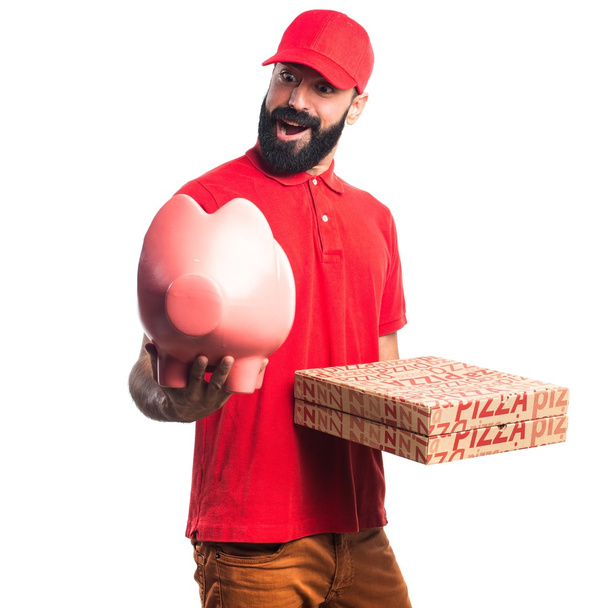 Pizza delivery man holding a piggybank - Foto, afbeelding